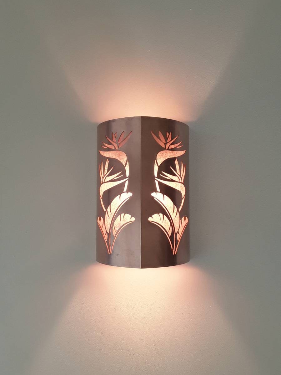 copper sconce light with a double cut out of a bird of paradise design with a white background