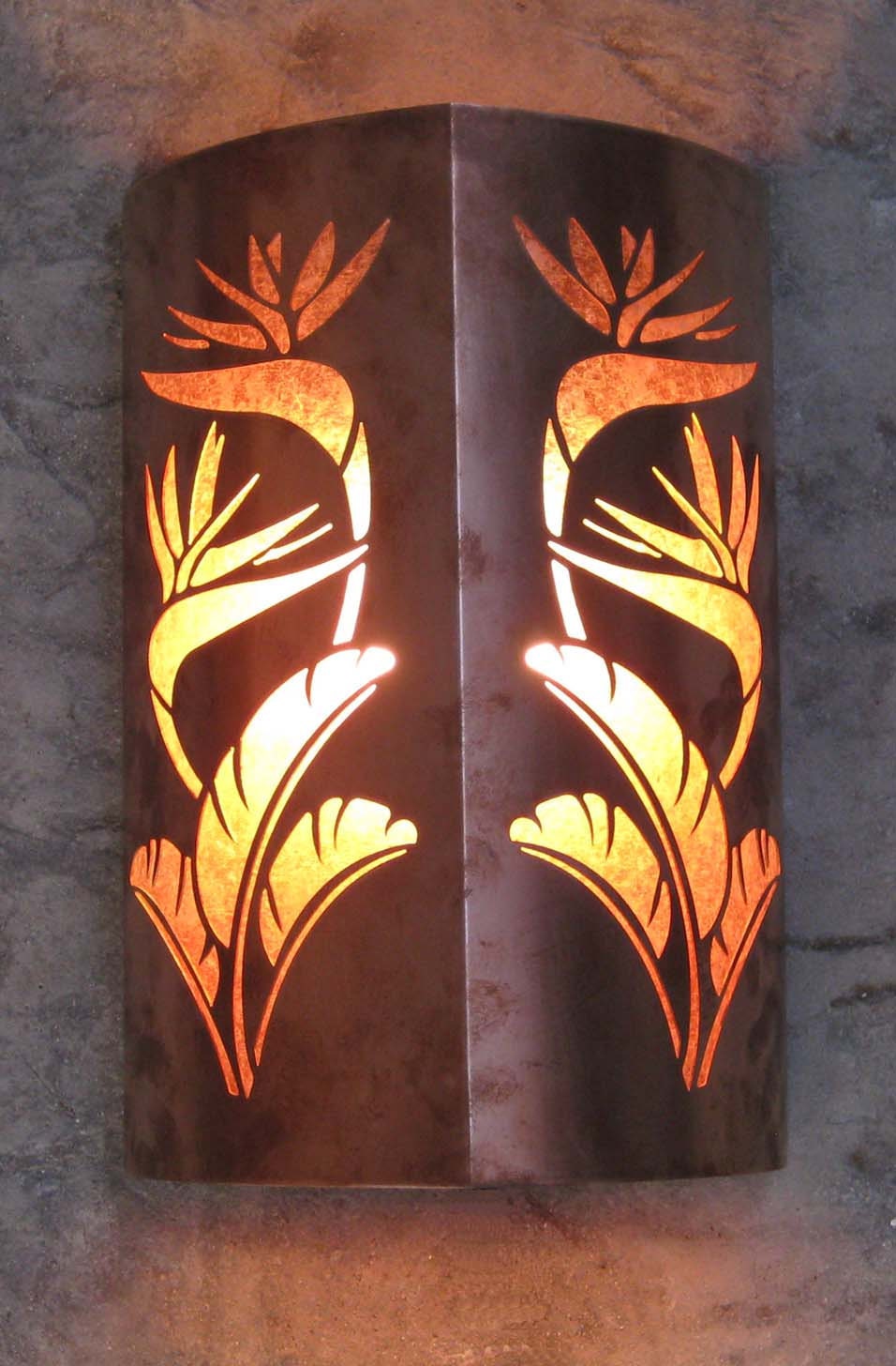 close up of a copper sconce light with bird of paradise design